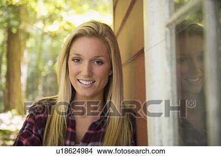 Portrait of young woman standing in front of house View Large Photo Image Picture - Portrait of young woman standing in front of house. Fotosearch