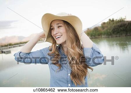 Stock Image - Portrait of young woman wearing hat. Fotosearch