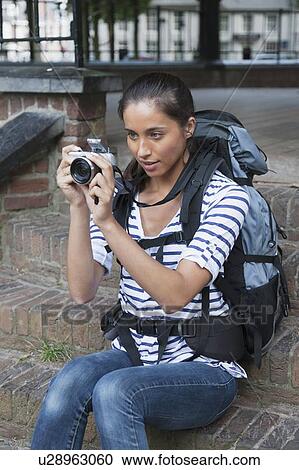 Portrait of young woman with backpack and camera View Large Photo Image Stock Image - Portrait of young woman with backpack and camera. Fotosearch