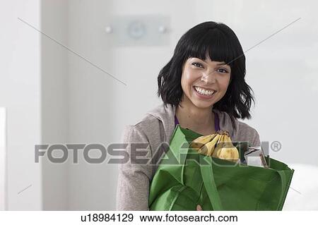 Portrait of young woman with shopping bag View Large Photo Image Stock Photo - Portrait of young woman with shopping bag. Fotosearch