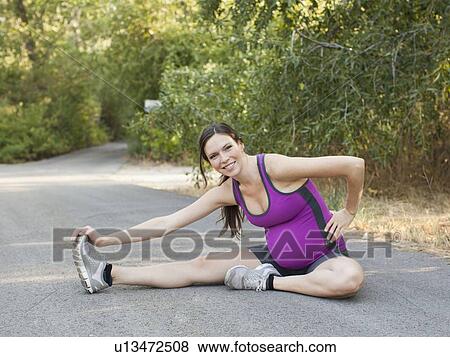 Pregnant mid adult woman in sport clothing stretching legs View Large Photo Image Stock Photo - Pregnant mid adult woman in sport clothing stretching legs. Fotosearch