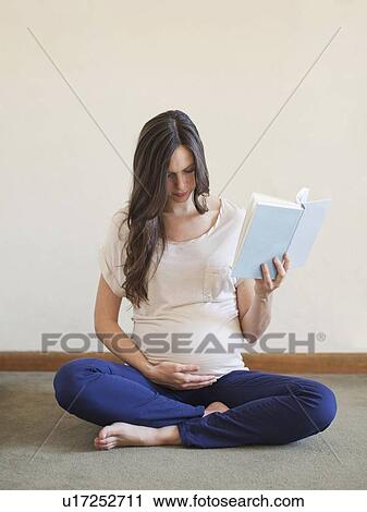 Pregnant mid adult woman sitting with crossed legs and holding book View Large Photo Image Stock Image - Pregnant mid adult woman sitting with crossed legs and holding book. Fotosearch