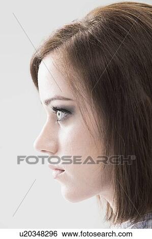 Profile of young woman, studio shot View Large Photo Image Stock Photograph - Profile of young woman, studio shot. Fotosearch