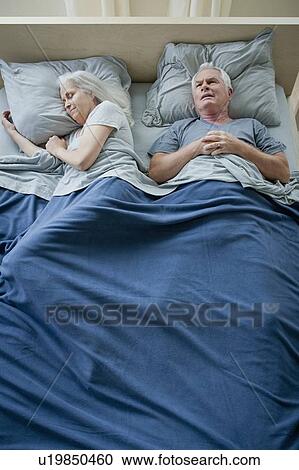 Stock Image - Senior couple sleeping in bed. Fotosearch