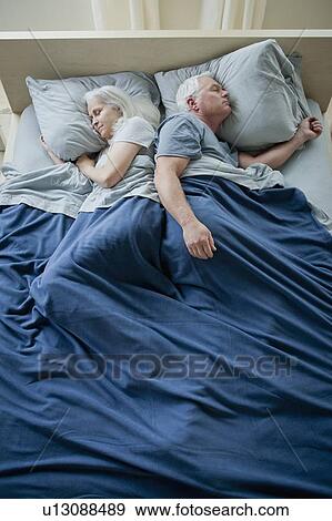 Senior couple sleeping in bed View Large Photo Image Stock Photo - Senior couple sleeping in bed. Fotosearch