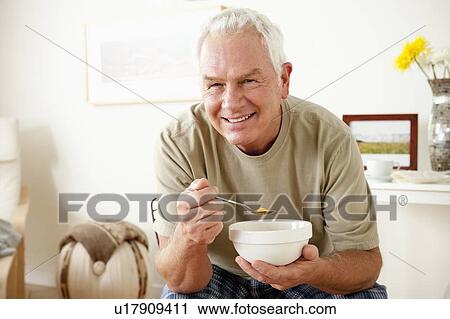 Senior man eating cereal from bowl View Large Photo Image Stock Image - Senior man eating cereal from bowl. Fotosearch