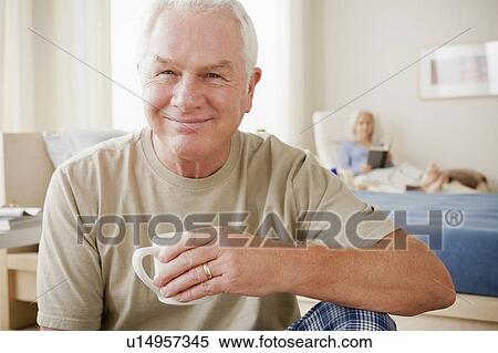 Stock Photography - Senior man holding coffee cup and smiling. Fotosearch