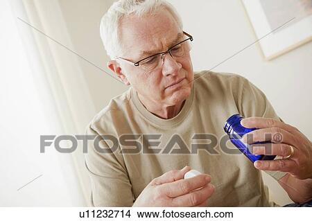 Senior man holding medicine flask View Large Photo Image Picture - Senior man holding medicine flask. Fotosearch