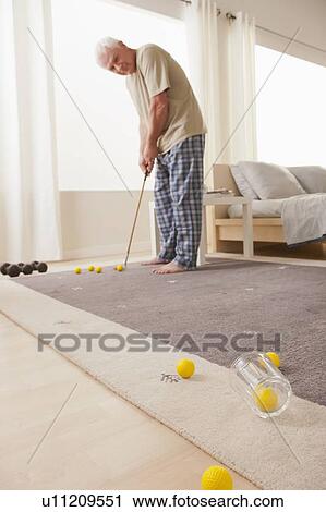 Senior man playing mini golf at home View Large Photo Image Stock Image - Senior man playing mini golf at home. Fotosearch