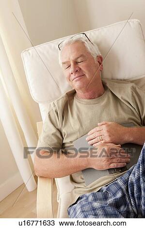 Senior man taking nap and holding book View Large Photo Image Stock Image - Senior man taking nap and holding book. Fotosearch