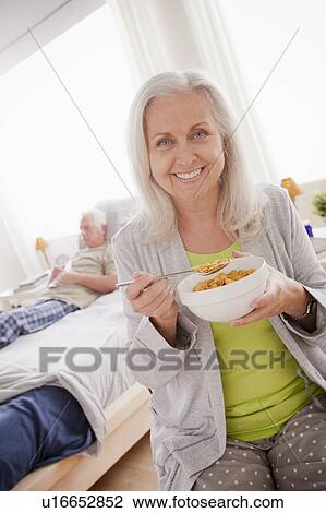 Senior woman eating cereal from bowl View Large Photo Image Stock Image - Senior woman eating cereal from bowl. Fotosearch