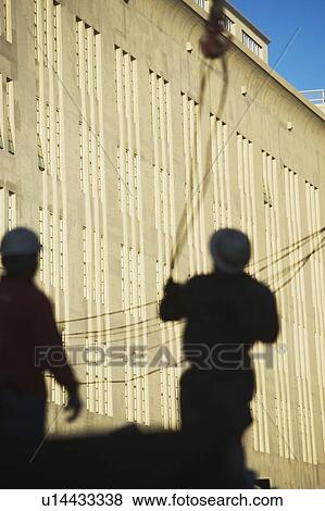 Shadows of construction workers on wall View Large Photo Image Stock Photo - Shadows of construction workers on wall. Fotosearch