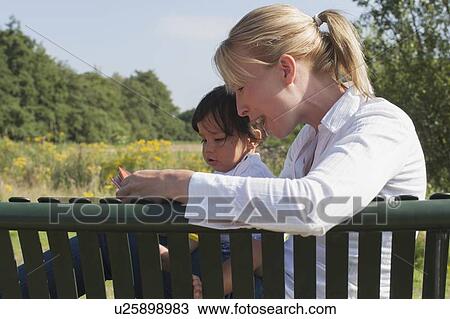 Side view of mother and her baby boy View Large Photo Image Stock Image - Side view of mother and her baby boy. Fotosearch