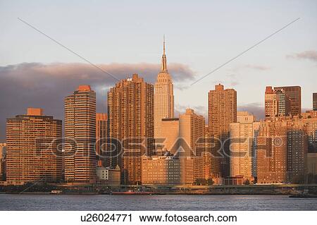 Stock Image - Skyline with Empire State Building at sunset. Fotosearch