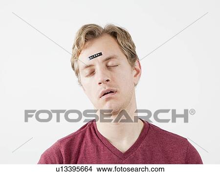 Sleeping man with sticker on his forehead View Large Photo Image Picture - Sleeping man with sticker on his forehead. Fotosearch