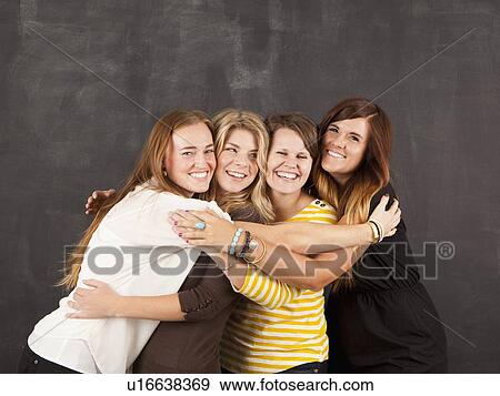 Stock Photo - Studio portrait of four women embracing. Fotosearch