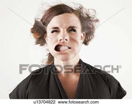 Studio portrait of young woman facing wind View Large Photo Image Stock Image - Studio portrait of young woman facing wind. Fotosearch
