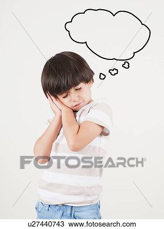 Stock Image - Studio shot of boy (6-7) with thought bubble. Fotosearch