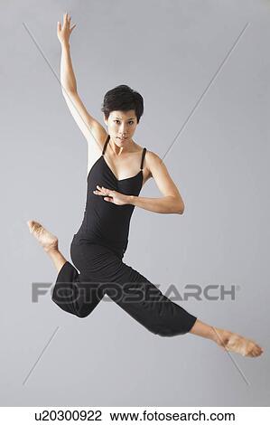 Stock Image - Studio Shot of jumping woman. Fotosearch