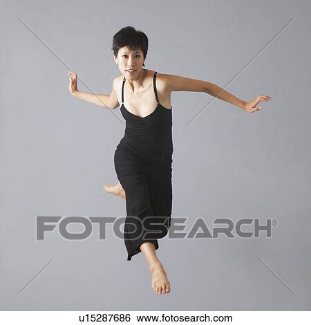 Studio Shot of jumping woman View Large Photo Image Stock Photograph - Studio Shot of jumping woman. Fotosearch