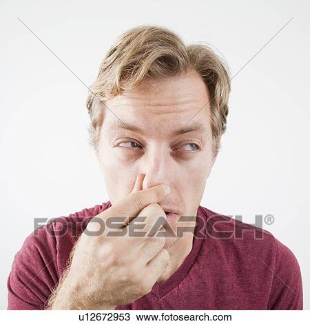 Studio Shot of mid adult man covering nose against unpleasant smell View Large Photo Image Stock Image - Studio Shot of mid adult man covering nose against unpleasant smell. Fotosearch