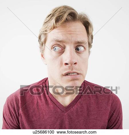 Stock Image - Studio Shot of mid adult man expressing fear with eyes wide open. Fotosearch