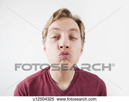 Stock Photography - Studio Shot of mid adult man puckering. Fotosearch