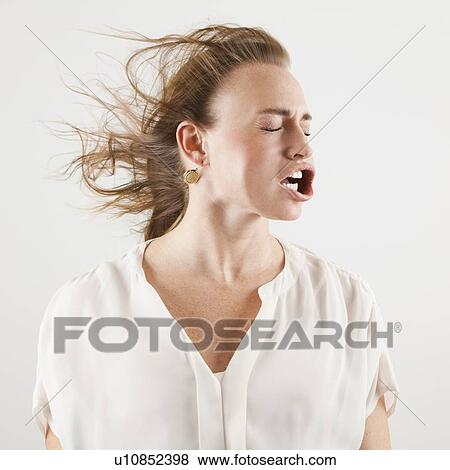 Stock Photo - Studio shot of woman with windblown mouth. Fotosearch
