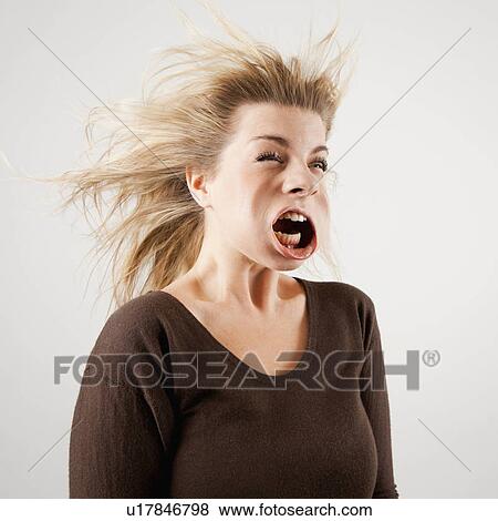 Stock Photo - Studio shot of woman with windblown mouth. Fotosearch