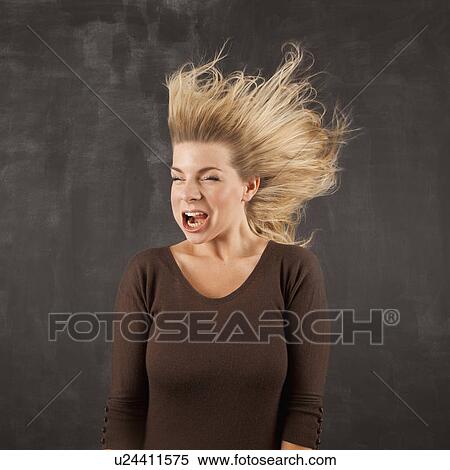 Stock Photography - Studio shot of woman with windblown mouth. Fotosearch