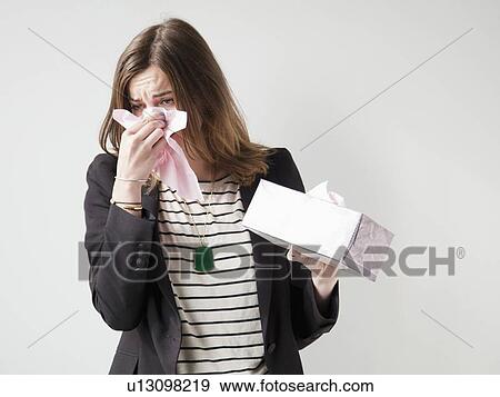 Studio shot of young woman sneezing View Large Photo Image Stock Photo - Studio shot of young woman sneezing. Fotosearch