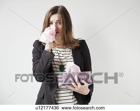 Studio shot of young woman sneezing View Large Photo Image Stock Photograph - Studio shot of young woman sneezing. Fotosearch