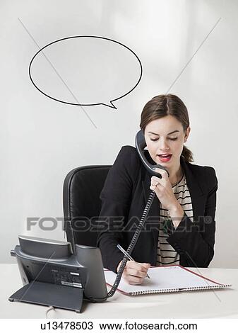 Studio shot of young woman talking on phone with speech bubble next to her head View Large Photo Image Stock Image - Studio shot of young woman talking on phone with speech bubble next to her head. Fotosearch