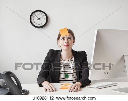 Studio shot of young woman working in office with adhesive note on her forehead View Large Photo Image Stock Image - Studio shot of young woman working in office with adhesive note on her forehead. Fotosearch