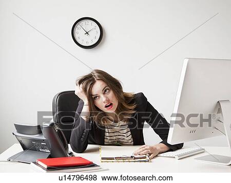 Studio shot of young woman working in office being under emotional stress View Large Photo Image Stock Photo - Studio shot of young woman working in office being under emotional stress. Fotosearch