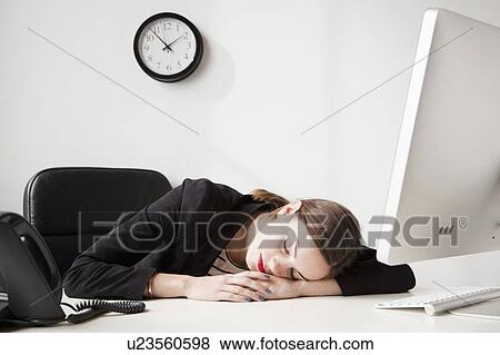 Studio shot of young woman working in office napping View Large Photo Image Stock Photo - Studio shot of young woman working in office napping. Fotosearch
