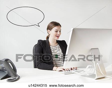 Studio shot of young woman working on computer with speech bubble next to her head View Large Photo Image Stock Photography - Studio shot of young woman working on computer with speech bubble next to her head. Fotosearch