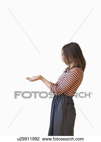Stock Image - Studio shot young woman bending over backwards pretending like holding something. Fotosearch