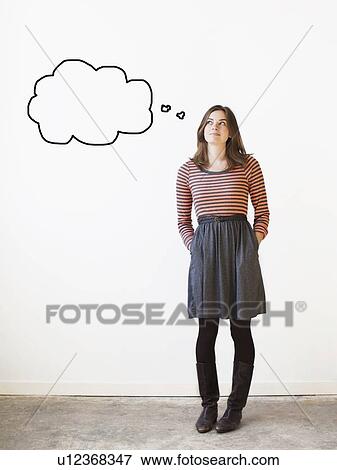 Stock Photo - Studio shot young woman looking up on thought bubble. Fotosearch
