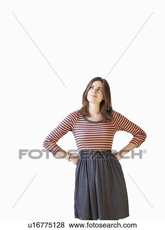 Studio shot young woman with hands on hip looking up View Large Photo Image Stock Photo - Studio shot young woman with hands on hip looking up . Fotosearch