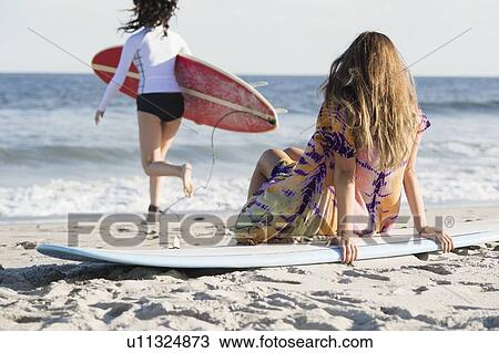 Two female surfers on beach View Large Photo Image Stock Image - Two female surfers on beach. Fotosearch