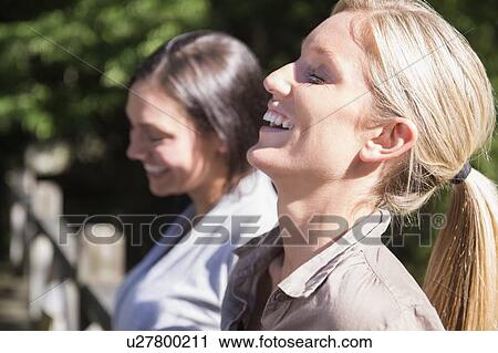 Two women smiling outdoors View Large Photo Image Stock Image - Two women smiling outdoors. Fotosearch