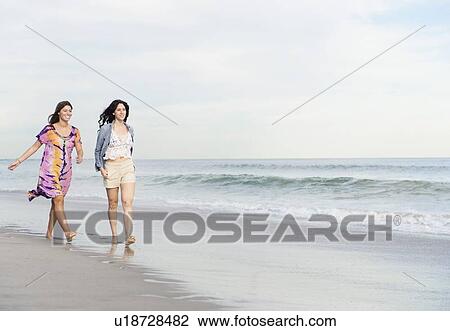 Two women walking on beach View Large Photo Image Stock Image - Two women walking on beach. Fotosearch