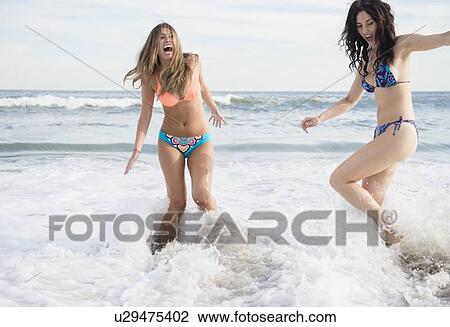 Two young women jumping in sea View Large Photo Image Stock Image - Two young women jumping in sea. Fotosearch