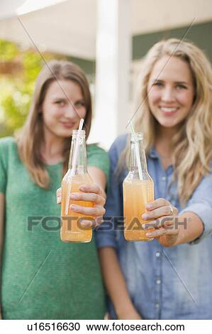 Stock Image - two young women with soda in focus. Fotosearch