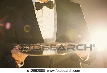 Waiter holding empty tray View Large Photo Image Stock Image - Waiter holding empty tray. Fotosearch