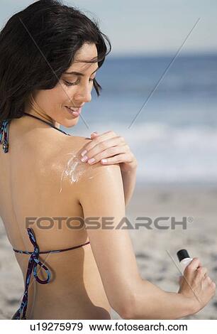 Woman applying suntan lotion at beach View Large Photo Image Stock Photo - Woman applying suntan lotion at beach. Fotosearch