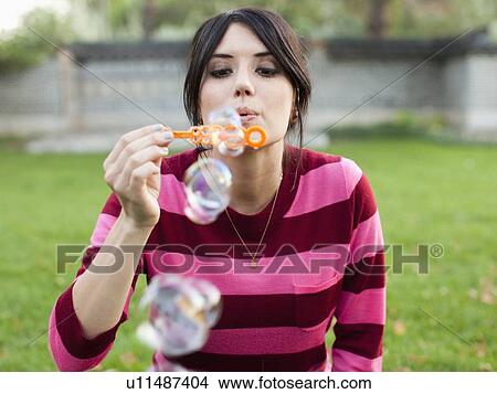 Picture - Woman blowing bubbles. Fotosearch