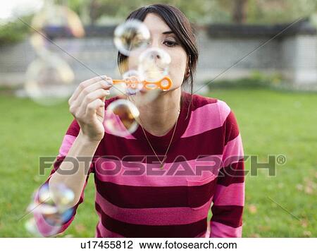 Stock Image - Woman blowing bubbles. Fotosearch