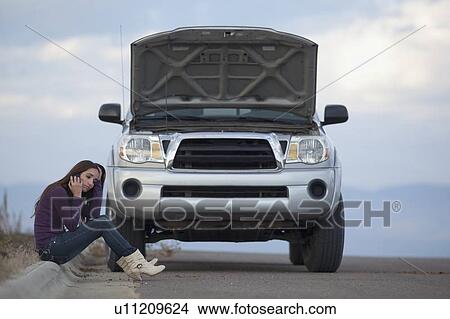 Woman calling for assistance after vehicle breakdown View Large Photo Image Picture - Woman calling for assistance after vehicle breakdown. Fotosearch